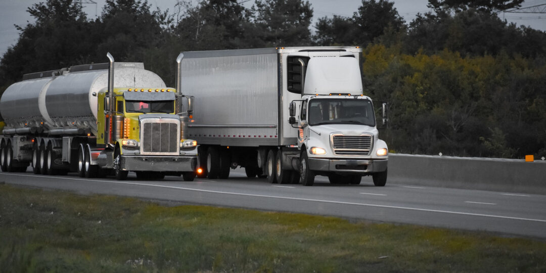 trailer-trucks-driving-road-surrounded-by-beautiful-green-trees-2-1-1080x540.jpg